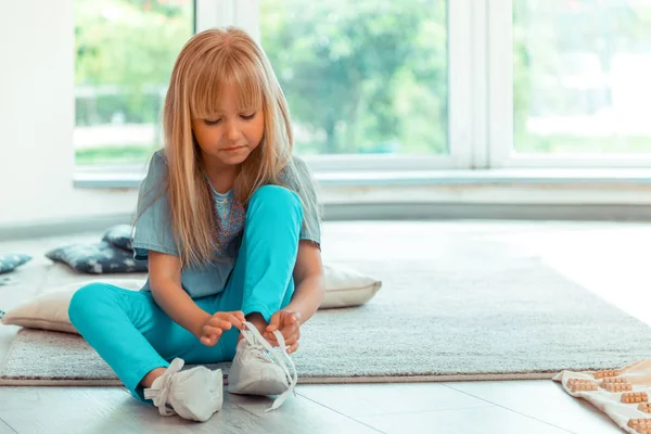 Hübsches süßes Mädchen schnürt ihre Schuhe — Stockfoto