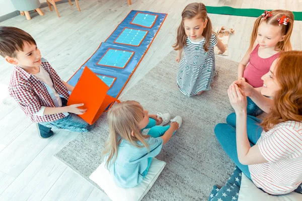 Positiv schöne Kinder, die mit einem Psychologen sitzen — Stockfoto