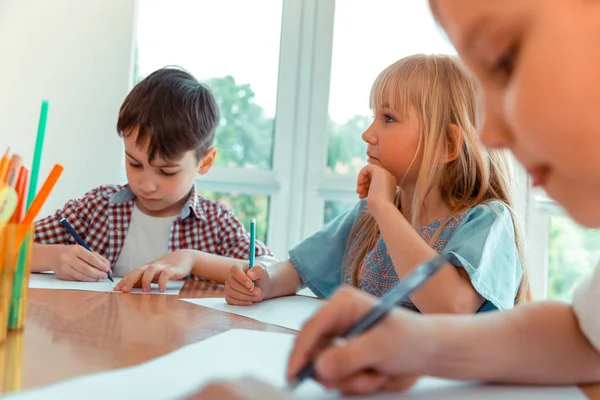 Bella ragazza bionda premurosa che disegna un quadro — Foto Stock