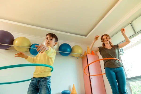 Mooie vrolijke vrouw die laat zien hoe je hula hoop draait — Stockfoto