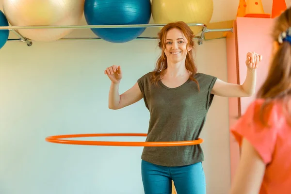 Mujer positiva feliz girando un aro de hula — Foto de Stock