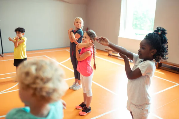 Дети начальной школы тренируются на спортивном уроке . — стоковое фото