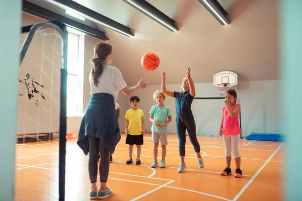 Barn som leker boll med sin tränare på Sports Class. — Stockfoto