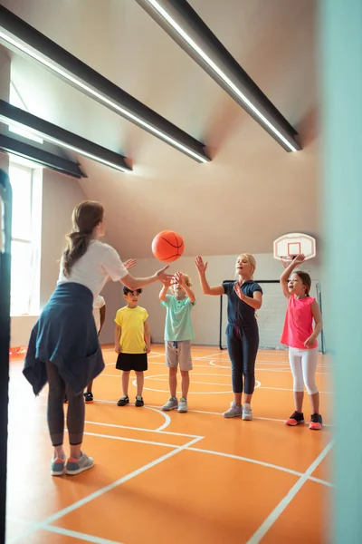 Professora de esportes jogando bola para seus alunos . — Fotografia de Stock