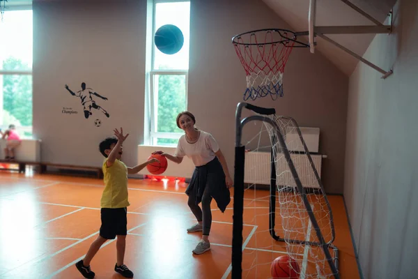 Professor de esportes jogando basquete com um de alunos . — Fotografia de Stock