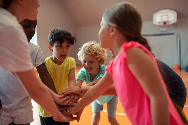 Alumnos emocionados tomados de la mano formando un círculo . — Foto de Stock