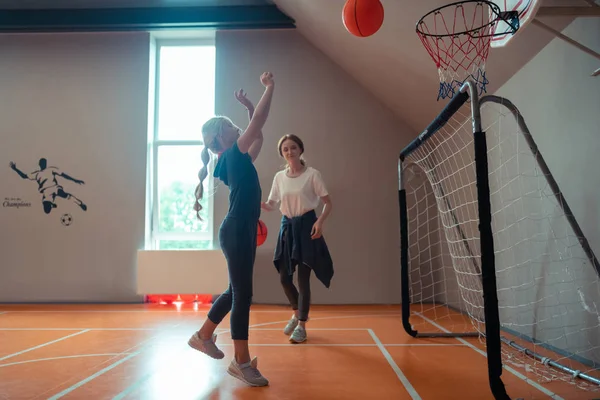 Шкільна дівчина грає в баскетбол зі своїм тренером . — стокове фото