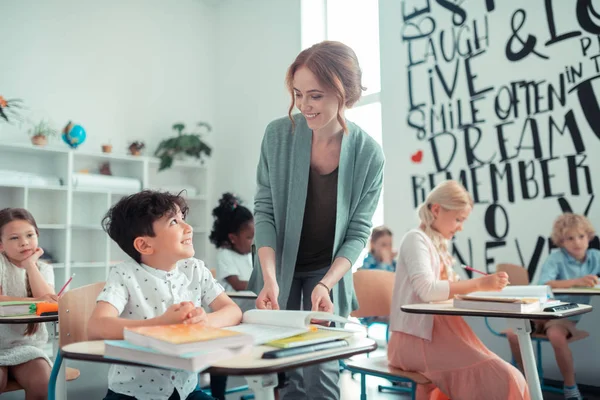 Cheerful pupil smiling to his kind teacher. — Stock Photo, Image