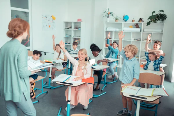 Mosolygó gyermekek egy osztályteremben kölcsönhatásban áll a tanár. — Stock Fotó