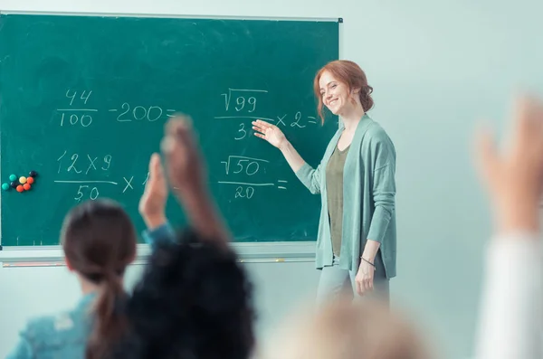 Lehrer erklärt Summen, die neben der Tafel stehen. — Stockfoto