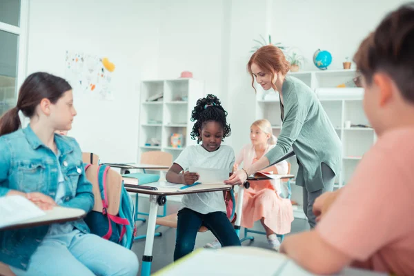 Profesora dándole a su alumno una tarea de prueba . — Foto de Stock