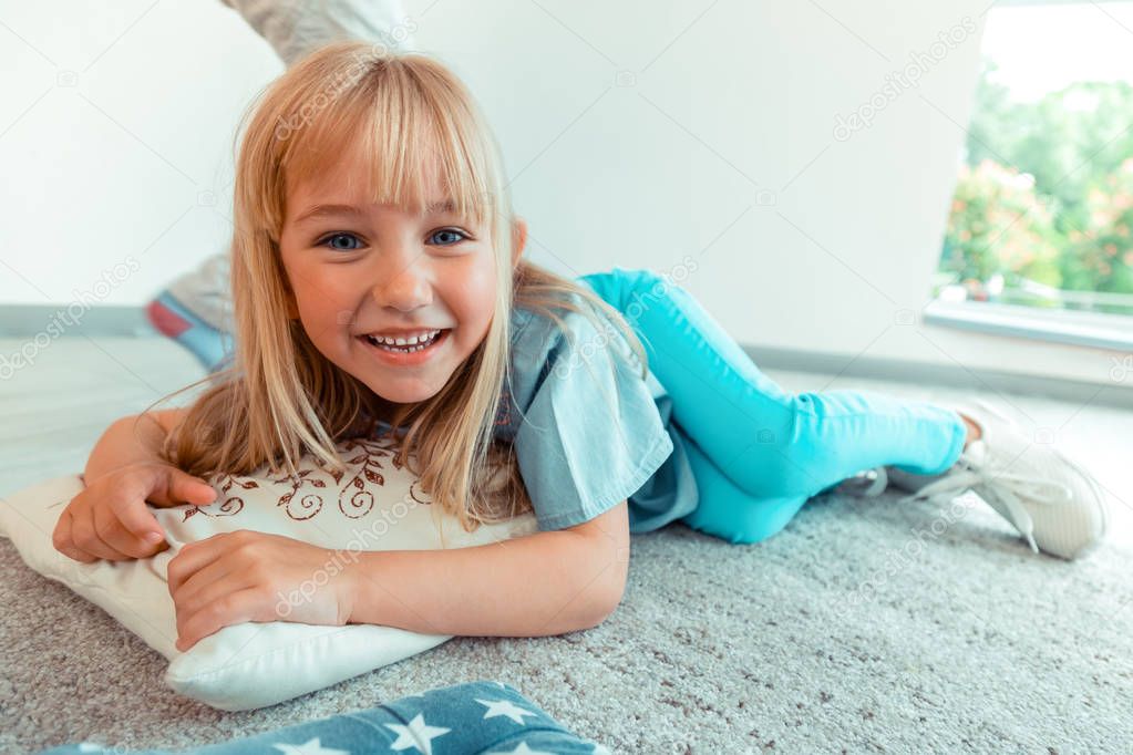 Joyful cute blond girl feeling absolutely comfortable