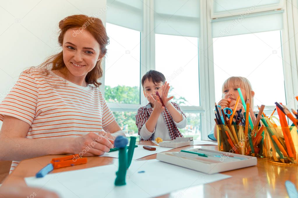 Positive nice woman looking at the handmade toy