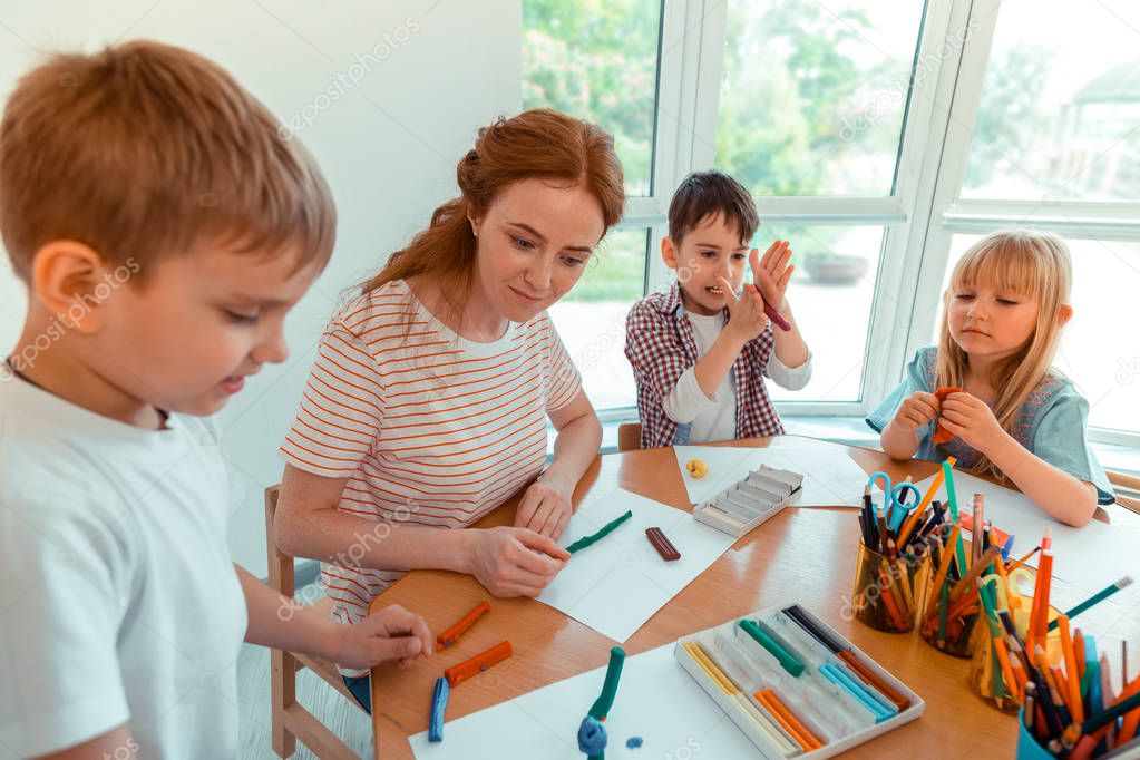 Nice joyful children playing with modeling clay