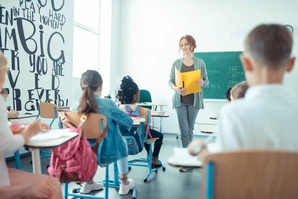 Teacher standing in front of her pupils in the classroom. — Stock Photo, Image