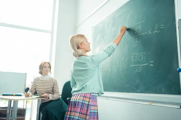 Menina atenta que trabalha no quadro negro durante a aula de matemática . — Fotografia de Stock