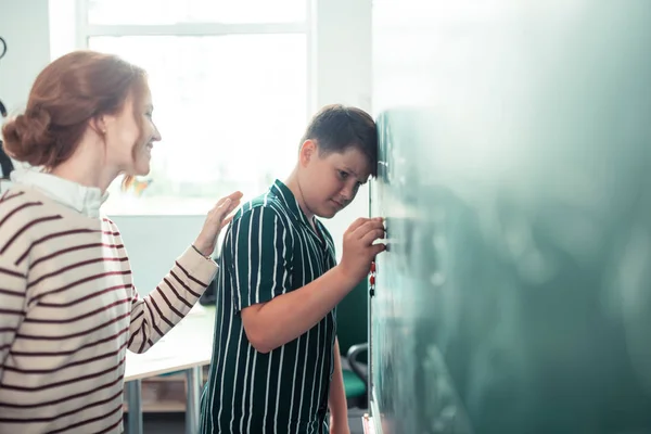 Öğretmen tahta nın yanında üzgün öğrenci neşelendirme. — Stok fotoğraf