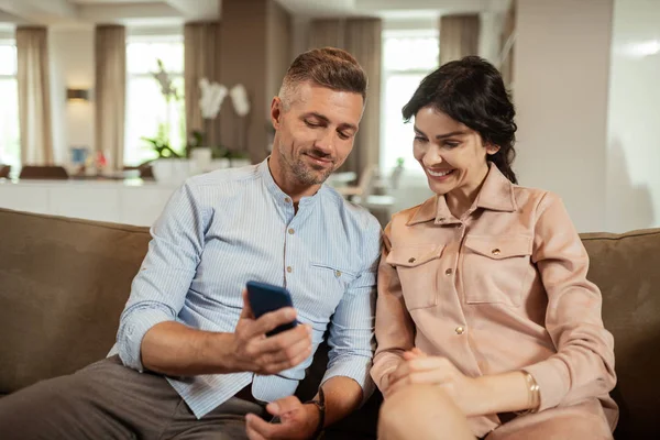 Esposa olhando para fotos de seu futuro nariz sentado perto do marido — Fotografia de Stock