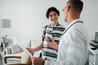 Plastik cerrah dinlerken gülümseyen kara gözlü kadın