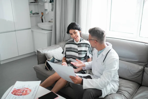 Woman smiling before plastic surgery while talking to doctor — Stock Photo, Image