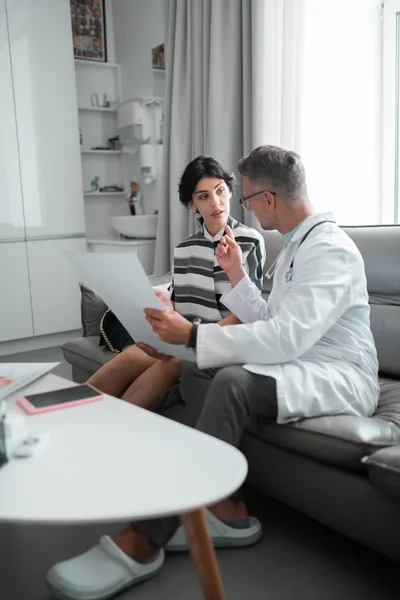 Cosmetics surgeon speaking to client about facial surgery — Stock Photo, Image