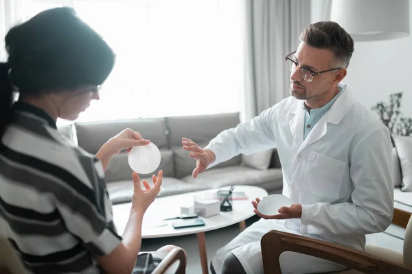 Woman looking at breast implants before having surgery — Stock Photo, Image