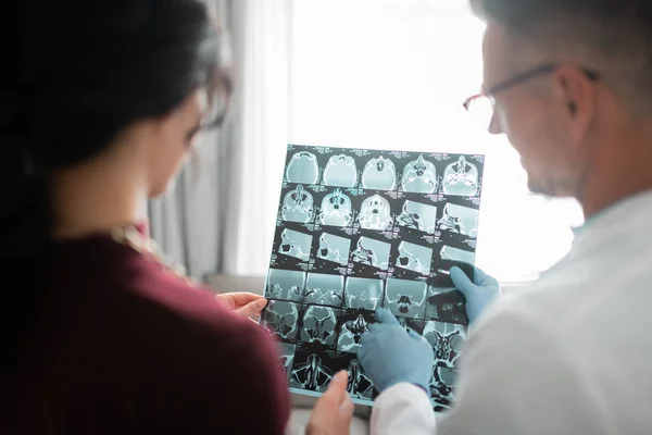 Plastic surgeon showing client her ultrasound of face