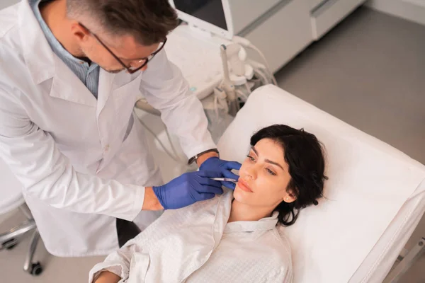 Cirujano plástico usando guantes haciendo inyecciones de botox — Foto de Stock