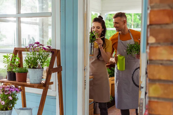 Dos compañeros de trabajo de pie detrás de la puerta de la floristería . — Foto de Stock