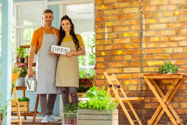 Two partners standing in front of their flower shop. — Stock Photo, Image