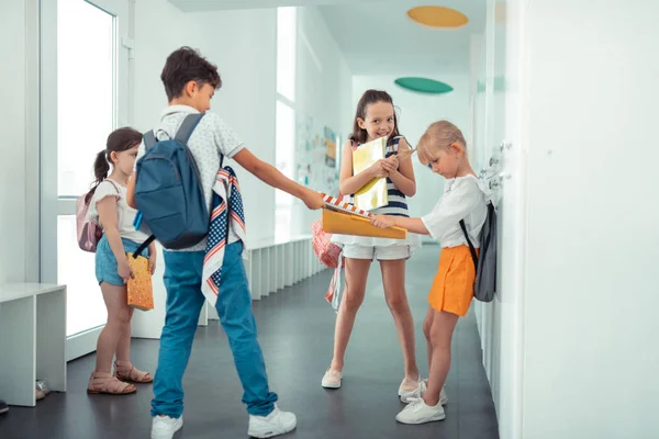 Grosero moreno chico tomando libro lejos de pequeña niña — Foto de Stock