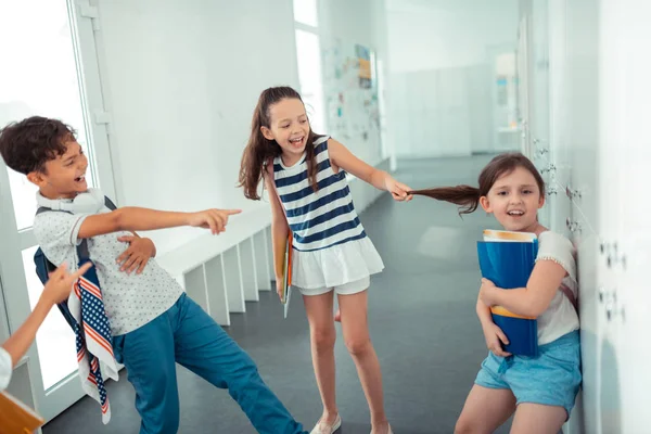 Rude violento bambini toccare i capelli di ragazza mentre il bullismo lei — Foto Stock