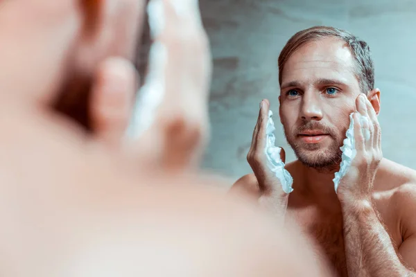 Сконцентрированный мужчина с утренними процедурами в ванной комнате — стоковое фото