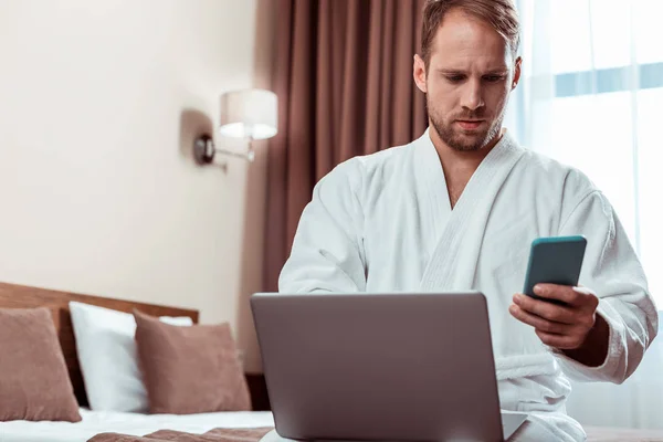 Attentive man with light stubble working on a laptop while sitting — Stock Photo, Image