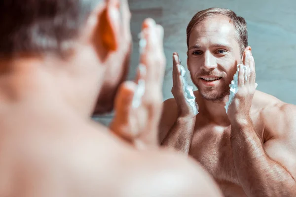 Beaming goed uitziende man bereidt gezicht voor het scheren — Stockfoto