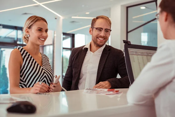 Glimlachende blonde vrouw die met haar bebaarde man op een receptie verblijft — Stockfoto