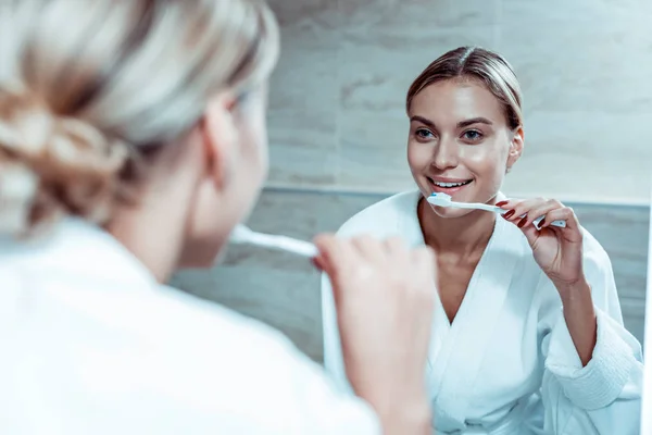 Mosolygós szőke hölgy tisztítás fogát a fogkrém — Stock Fotó