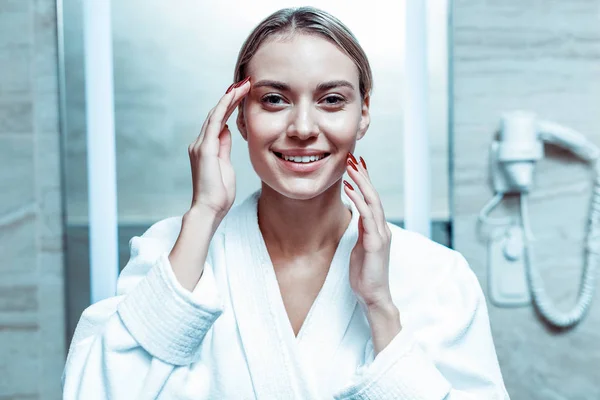 Senhora alegre e bonita com cabelo amarrado desfrutando de sua pele impecável — Fotografia de Stock