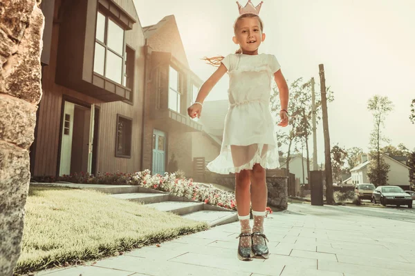 Aktywna chuda dziewczyna w całkiem białej sukni skoki na ulicy — Zdjęcie stockowe