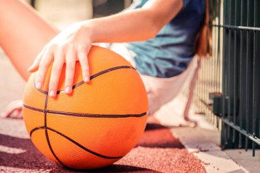 Turuncu basketbol topu tutan küçük elleri ile küçük kız