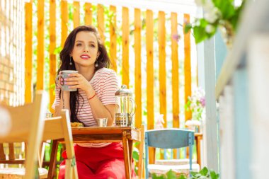 Kafe masasında oturan düşünceli kadın.