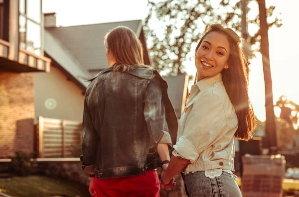 Beautiful Asian girl turning around while walking with tall boyfriend — Stock Photo, Image