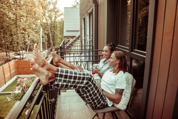Χαρούμενο ζευγάρι που γέρνει στο μεταλλικό κιγκλίδωμα σε ένα μπαλκόνι — Φωτογραφία Αρχείου