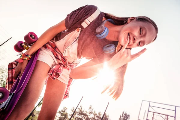 Beaming menina de cabelos longos estar em ótimo humor enquanto ficar fora — Fotografia de Stock