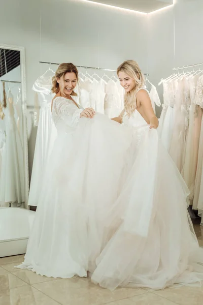 Two brides looking at the dresses of each other. — Stock Photo, Image