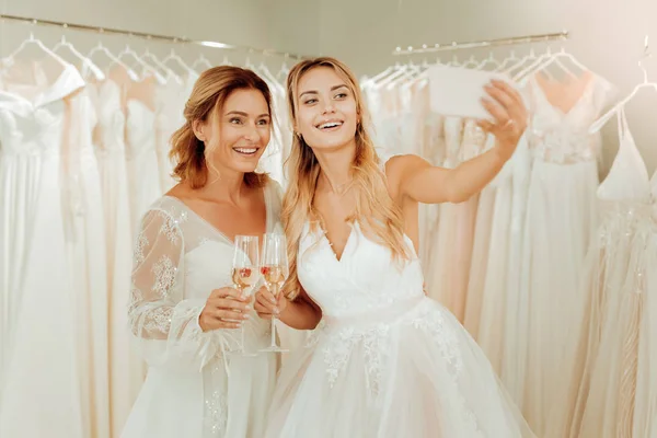 Két boldog nő vesz selfies esküvői ruhák. — Stock Fotó