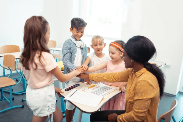 Bambini e insegnante godendo il loro lavoro di squadra tutti insieme — Foto Stock