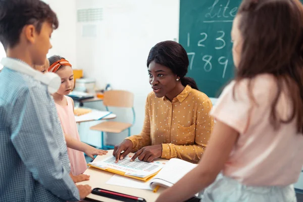 Professional teacher of primary school speaking with pupils — Stock Photo, Image