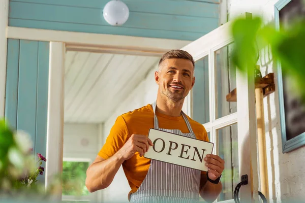 Flower shop owner smiling to his first customers. — Stock Photo, Image