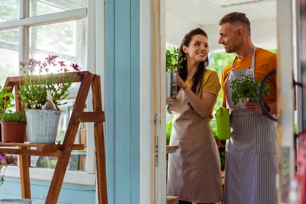 Coppia felice aiutandosi a vicenda in un negozio di fiori . — Foto Stock